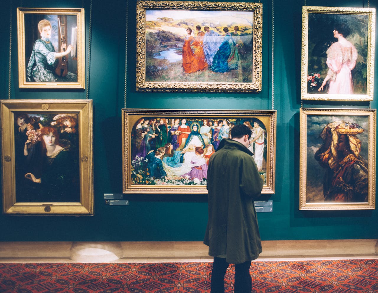 Person views classic artworks in an elegant gallery setting, exploring art history.
